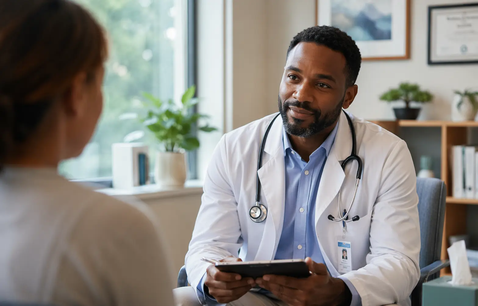 A compassionate Black male doctor sits in a softly lit, modern clinic office, attentively listening to a patient during a consultation, creating a calm and supportive atmosphere for discussing mental health 