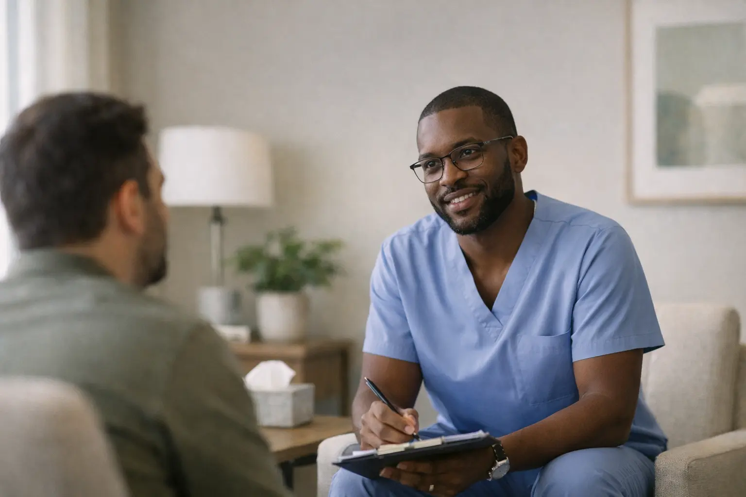 Black male psychiatric nurse practitioner providing compassionate mental health care during a one on one consultation, actively listening to a patient in a calm, modern clinic setting 